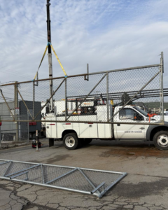 A large chain-link gate being installed with a crane by Gilliam Services LLC in Johnson City, TN.