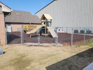 A chain link fence enclosing a children's playground installed by Barney's Landscaping in Dayton, OH.