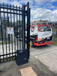 A black chain-link sliding gate with a Viking gate operator motor installed by Motor & Fence Solutions in Miami, FL.