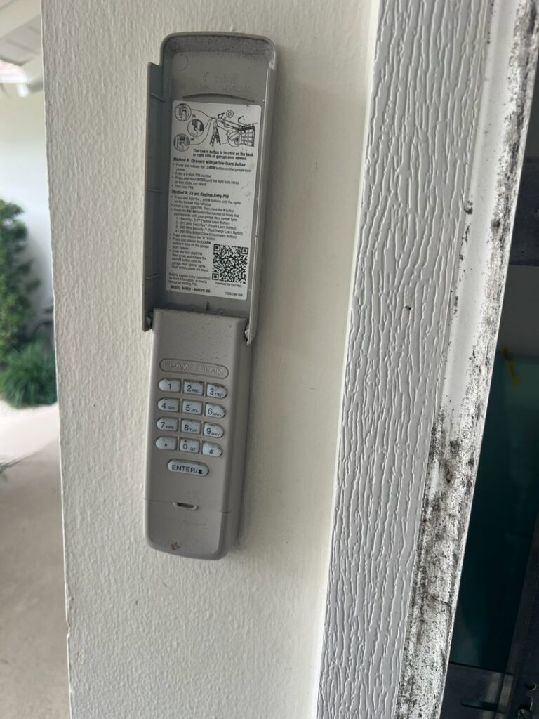 A Chamberlain garage door keypad mounted on a wall, showcasing an installation by BSD Garage Door Service in Naperville, IL.