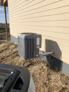 A Champion outdoor AC unit securely mounted to the side of a new construction home by Air Care in Sioux Falls, SD.