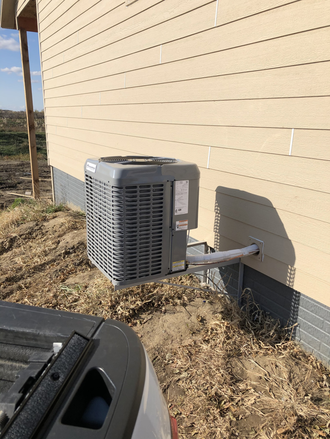 A Champion outdoor AC unit securely mounted to the side of a new construction home by Air Care in Sioux Falls, SD.