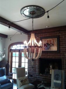 A large decorative chandelier and string lights installed in a living room by In the Light Electrical LLC in Kansas City, KS