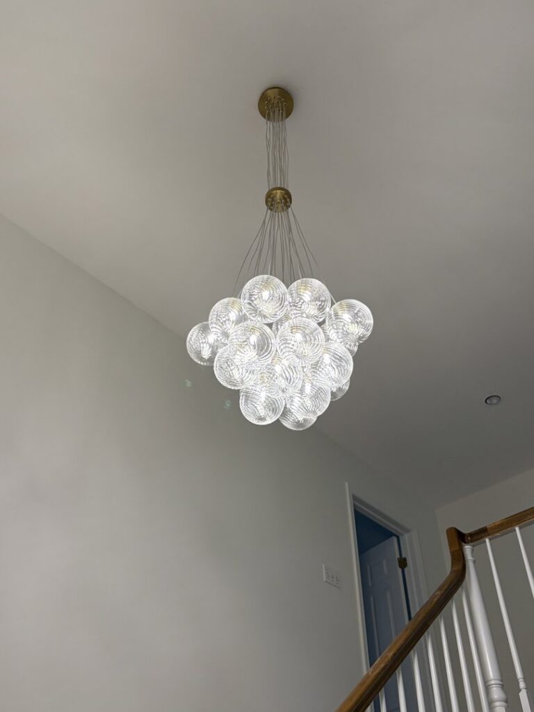 Large decorative chandelier expertly installed in a stairwell by The Dorky Electrician, LLC in Coplay, PA