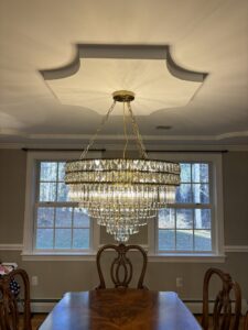 A beautiful chandelier installation in a dining room by Kevin Kelley Electrical Inc in Leominster, MA.
