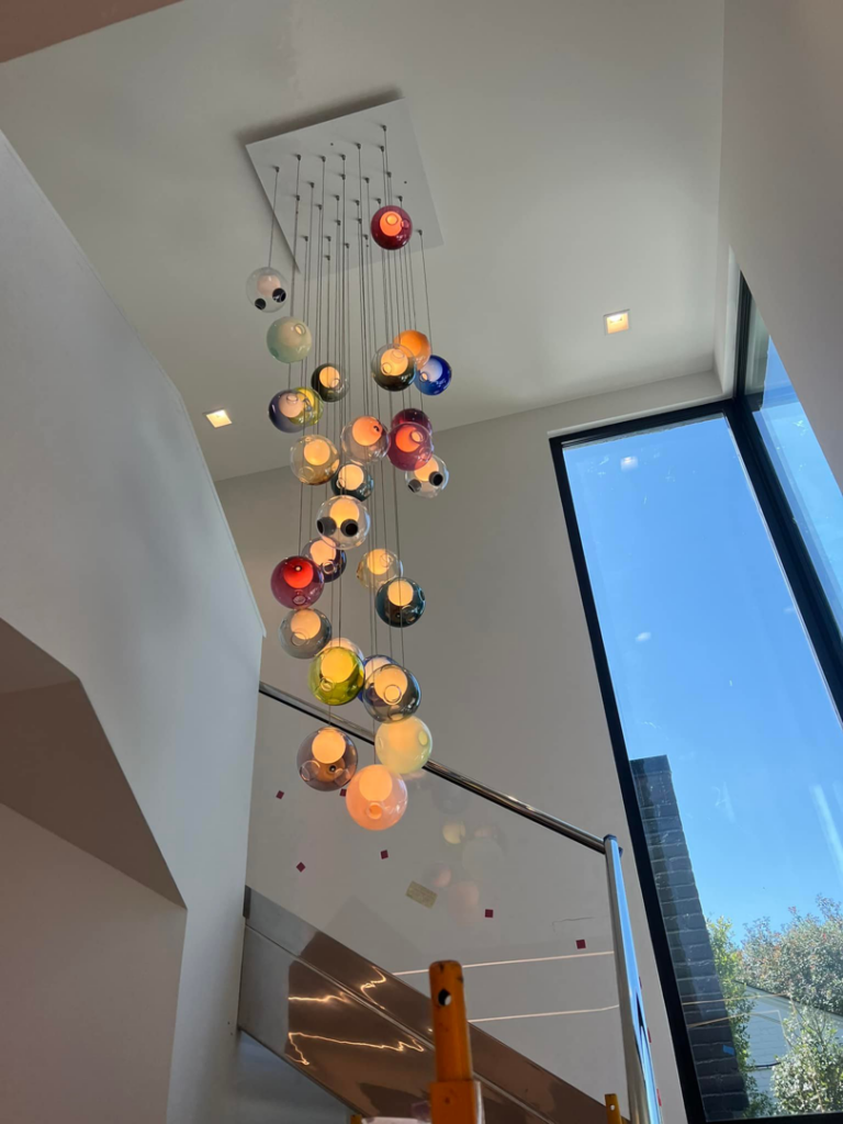A stunning multi-bulb chandelier installed in a high ceiling by Krajcer Electric in New Orleans, LA
