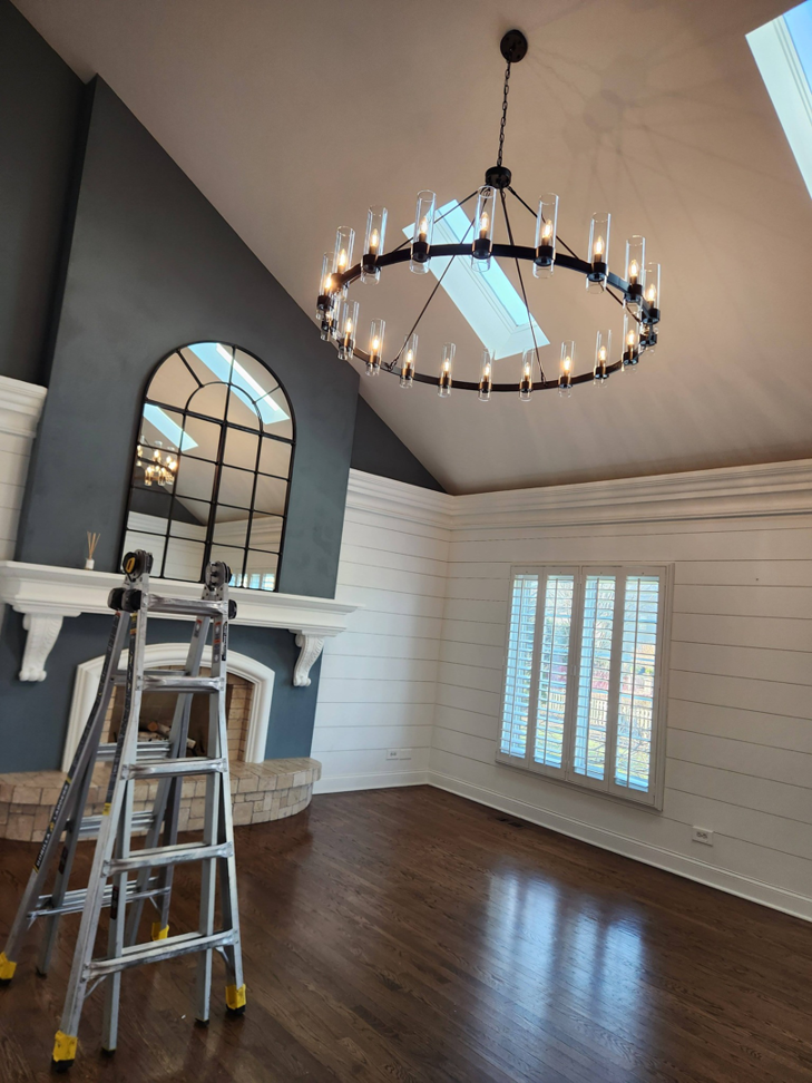 A circular chandelier installed in a room with a sloped ceiling by Ed's Electrical & Mounting services in Chicago, IL.