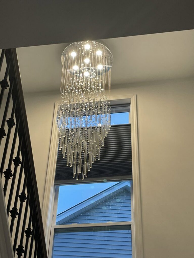 A large, decorative chandelier installed in a stairwell by Clarity Handyman Service in Raleigh, NC