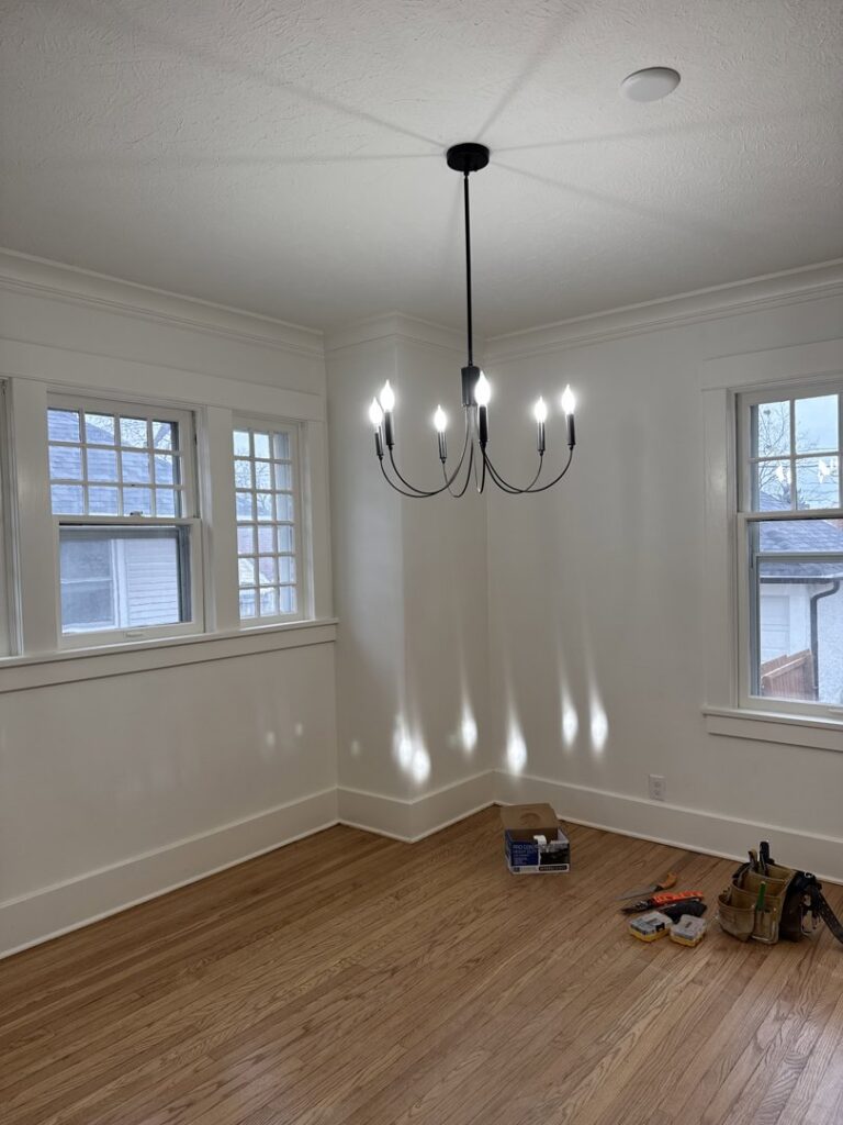 Chandelier installation in a room with tools on the floor, performed by TF Electrical Solutions in Omaha, NE.