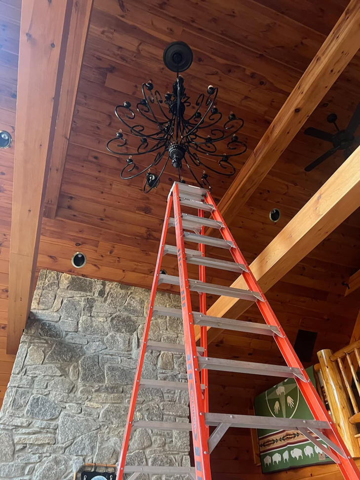 An electrician's ladder positioned for chandelier installation or repair on a high wooden ceiling by TD Electric in Waterbury, CT.