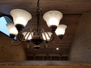 A beautiful chandelier installed on a wooden ceiling by Grason Electric in Fort Collins, CO.