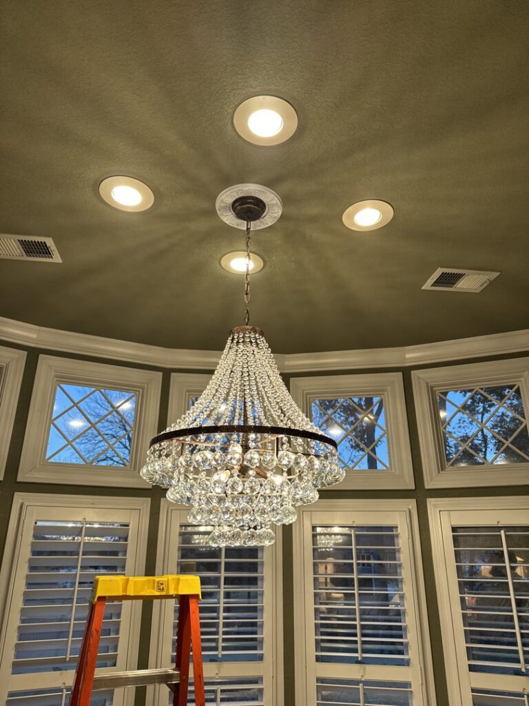 A large chandelier and recessed lighting installation with a ladder, by Delta Current Electric in Jonesboro, AR.