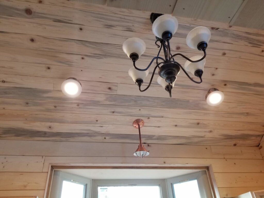 Chandelier and recessed lighting installed on a wooden ceiling by Grason Electric in Fort Collins, CO.