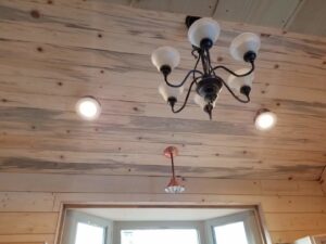 Chandelier and recessed lighting installed on a wooden ceiling by Grason Electric in Fort Collins, CO.