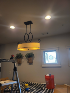 A newly installed chandelier and recessed lighting in a room by Joe Does It-Electrical Services in Atlanta, GA.