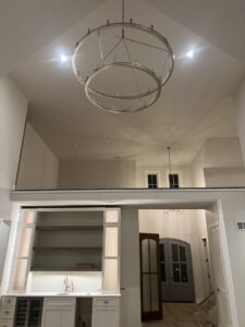 Chandelier and recessed lighting installed in a high-ceiling room by Pinnacle Electric Solutions in Port St. Lucie, FL.