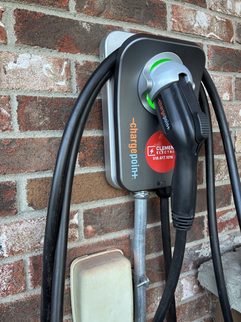 A ChargePoint EV charger installed on a brick wall by Clemens Electric in Averill Park, NY