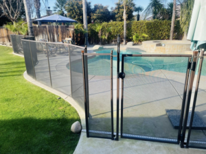 A close-up of a child safety pool fence gate, installed for maximum security by A Safe Pool Enclosures in Bakersfield, CA.