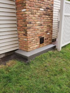 New concrete work completed at the base of a brick chimney by JJ Chimney Services in Minneapolis, MN.