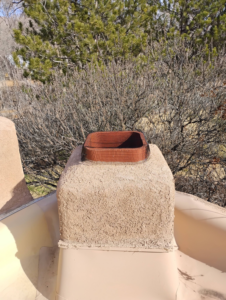 A chimney cap with a mesh screen installed for wildlife exclusion by Pestpuncherspcs in Rio Rancho, NM.