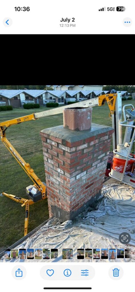 A chimney reconstruction project in progress on a roof, with a lift truck providing access, by Harry's Quality Chimney Services in Kansas City, MO