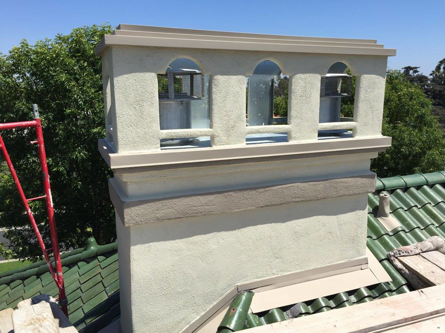 A chimney on a rooftop with scaffolding, indicating repair or maintenance work by Fireplace Freddie in Shadow Hills, CA.