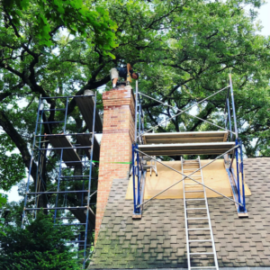 A professional worker on scaffolding performing chimney repair for The Chimney Sweep in Stafford, VA.