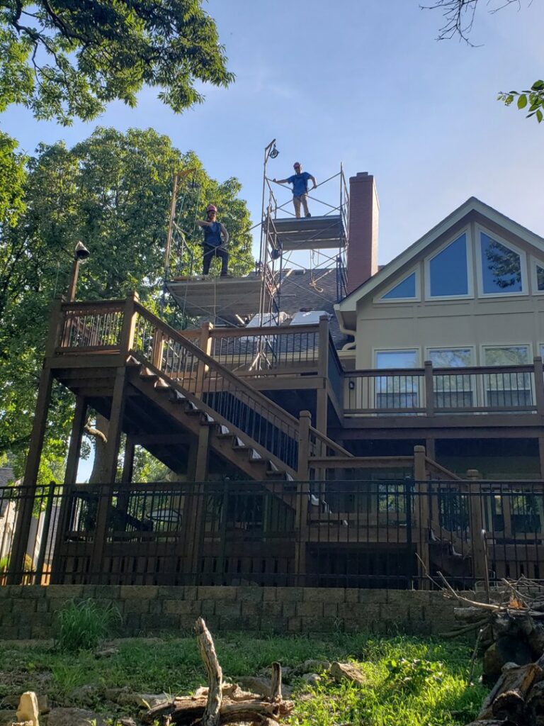 Two workers on scaffolding performing chimney repair for Full Service Chimney in Overland Park, KS