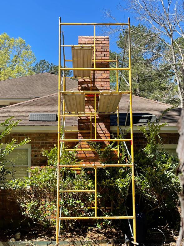 Scaffolding set up around a brick chimney for service by Louisiana Chimney Services in Shreveport, LA.
