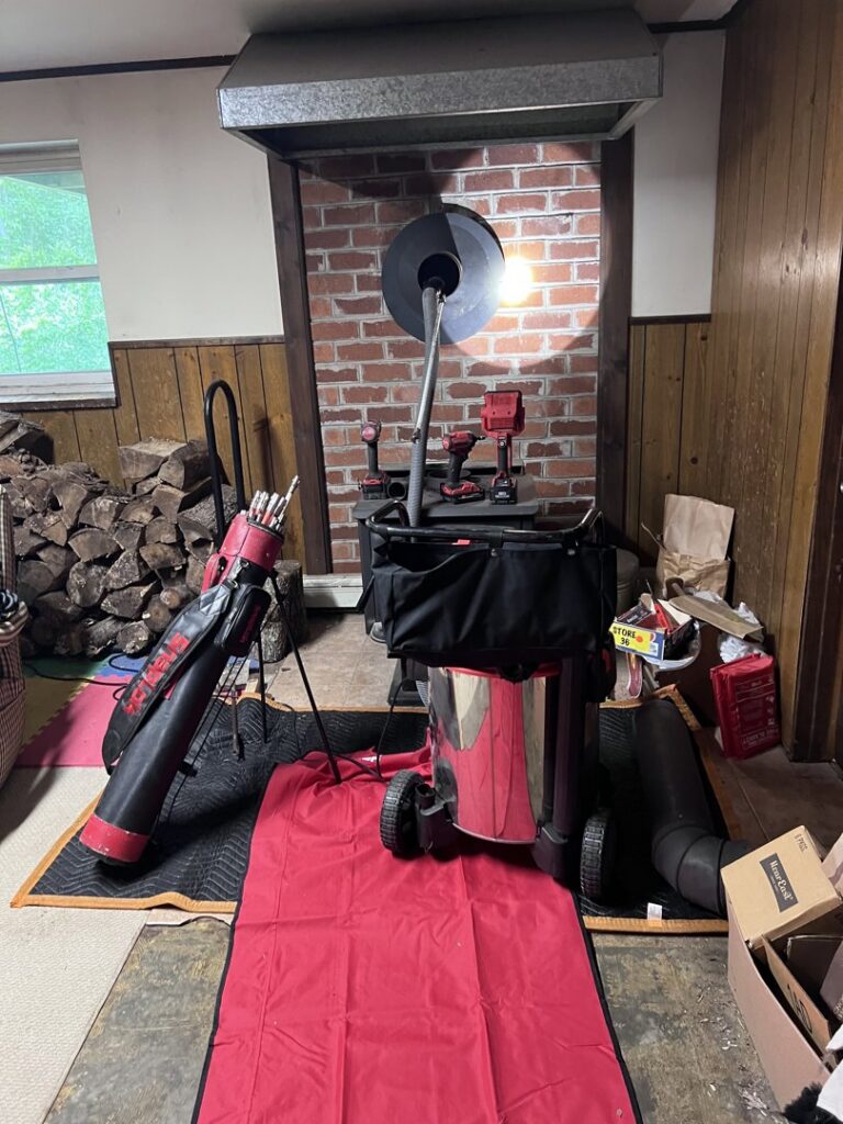 Chimney sweep equipment and tools set up in front of a fireplace for a job by Granite State Chimney in Manchester, NH