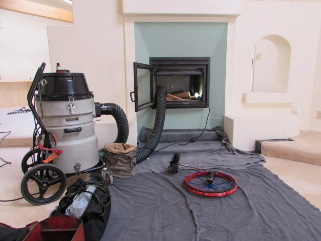 Chimney sweep equipment, including a vacuum and brushes, set up for a job by Denver Chimney Sweep in Denver, CO.