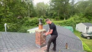 A Certified Masons professional performing a chimney sweep or inspection on a roof in Warwick, RI