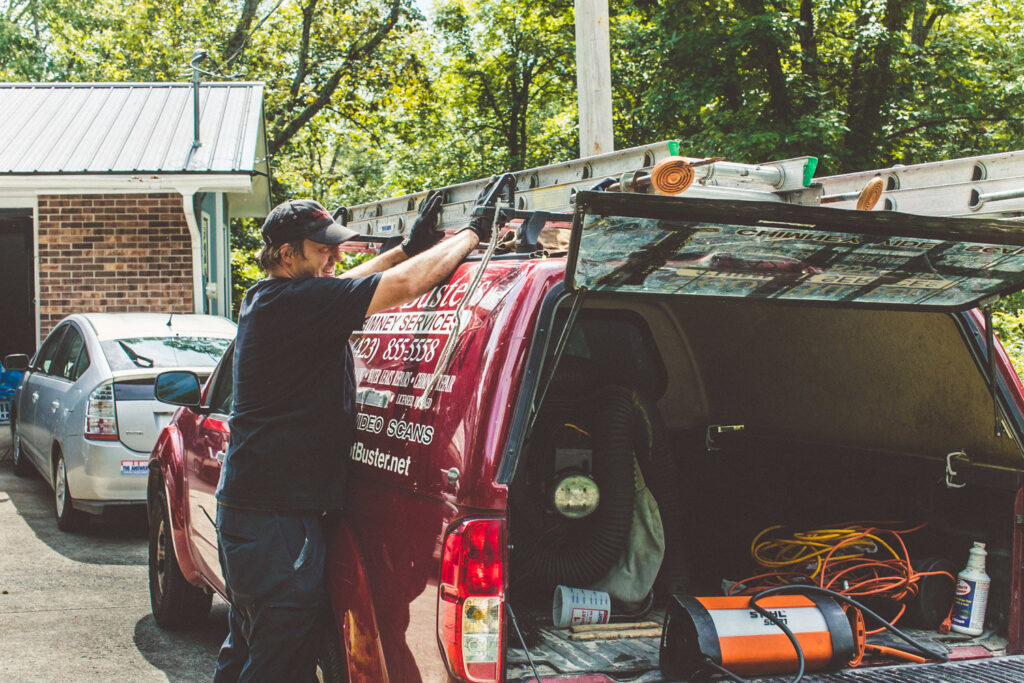 A chimney sweep from Soot Busters loading equipment into a company truck before or after a job in Birmingham, AL.