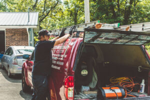 A chimney sweep from Soot Busters loading equipment into a company truck before or after a job in Birmingham, AL.