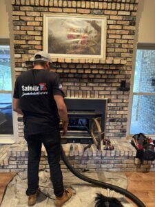 A SafeAir Duct & Chimney technician preparing for a chimney sweep with tools and vacuum in Dallas, TX
