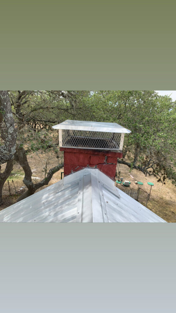 A chimney with a new cap installed on a metal roof by The Texan Chimney Sweep San Antonio, TX.