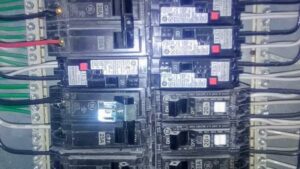 A close-up view of circuit breakers and wiring inside an electrical panel, serviced by Jimenez Electric Inc in Denver, CO.