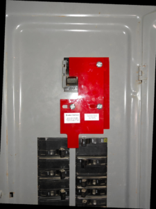 Close-up of a circuit breaker panel featuring a red generator interlock kit installed by Sherrill Company, LLC Electrical Contractors in Columbus, GA.