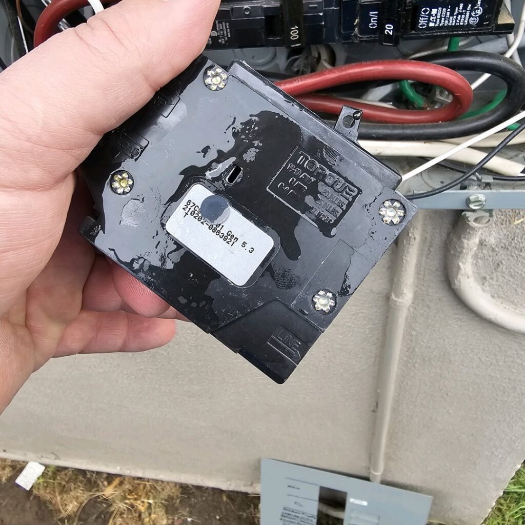 A hand holding a circuit breaker, indicating replacement or installation by Bee Thumb Electric in North Highlands, CA.