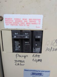 A close-up of circuit breakers in an electrical panel, labeled for pump, GFI, and light, by Tenax Electrical Company in Jacksonville, FL.