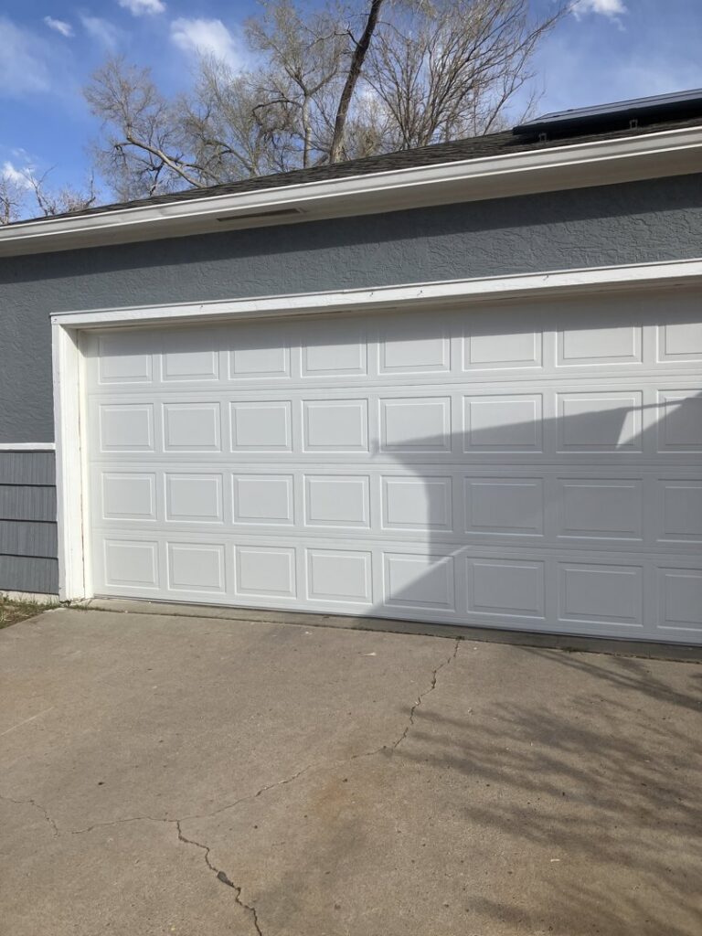 A classic white panel garage door installed on a residential home by Prutch's Garage Door in Colorado Springs, CO.
