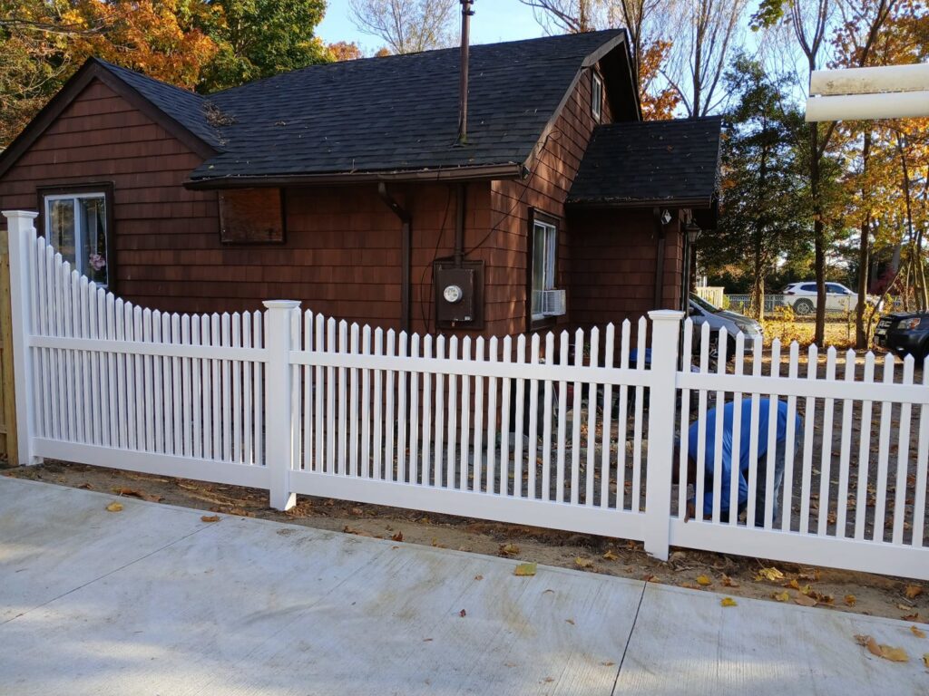 A classic white picket fence enhancing the curb appeal of a front yard, installed by Zelaya Fence in New York City, NY.