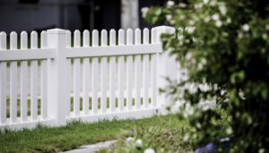A beautiful classic white picket fence installed in a garden by Superior Fence & Rail Richmond, VA.