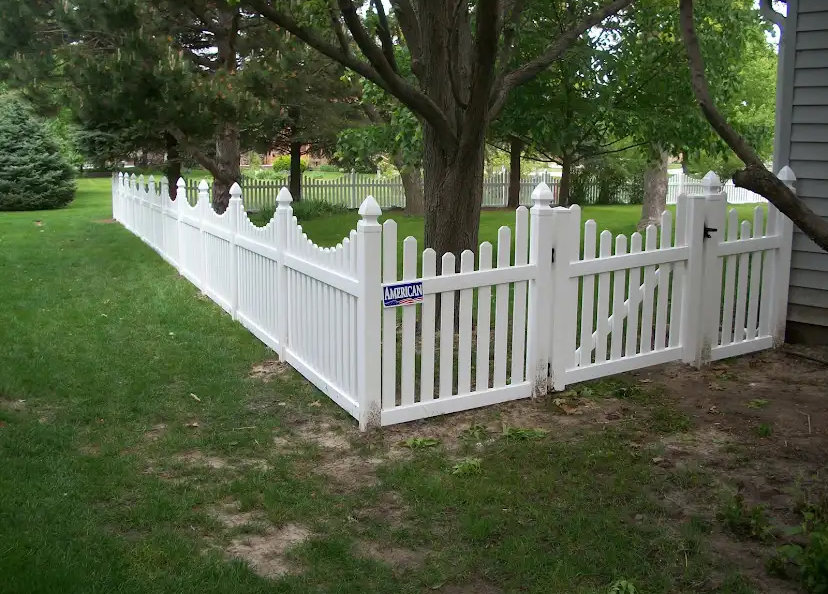 A classic white picket fence with a matching gate installed in a residential yard by Discount Fence Supply in Great Falls, SC.