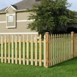A classic wooden picket fence with a gate surrounding a residential yard by Fence Company Chicago in Chicago, IL
