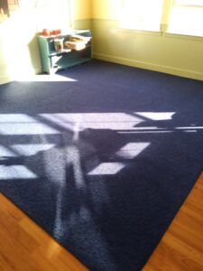 A clean, dark blue area rug in a sunlit room after professional service by My Dad's Floor and Upholstery Cleaning in Sacramento, CA.