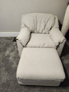 A clean upholstered armchair and ottoman on a freshly cleaned carpet by Fiber Dry Carpet & Upholstery Cleaning in Dayton, OH.