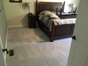 A freshly cleaned, light-colored carpet in a bedroom, demonstrating the excellent service of Yellow Finch Carpet Cleaning LLC in Dover, NH.