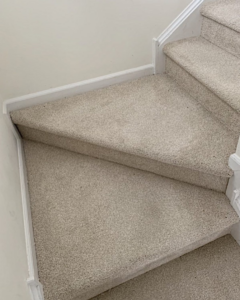 A clean, light beige carpet installed on a stair landing and steps by GC&D Flooring in Allentown, PA.