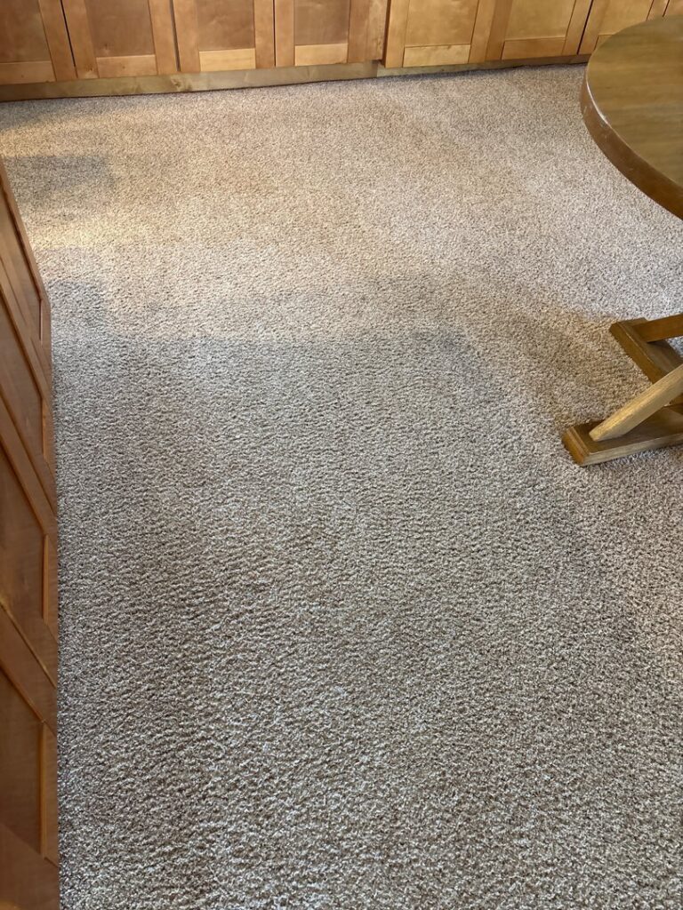 A freshly cleaned carpet in a kitchen and dining area, showcasing the results from Heaven's Best Carpet Cleaning San Diego CA.